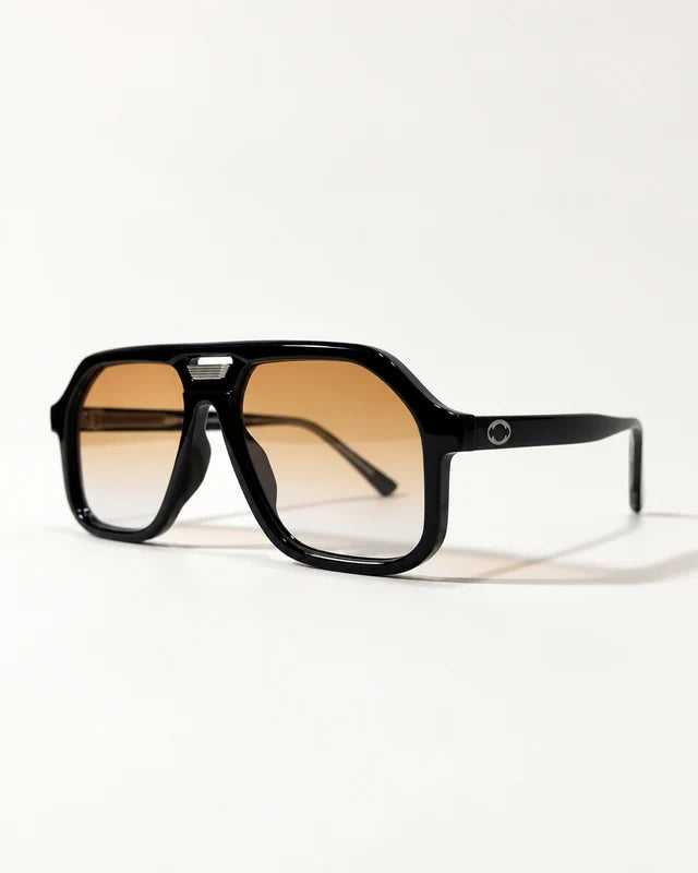 AUR-002 black double-bridge frame with amber gradient lenses, three-quarter photograph.